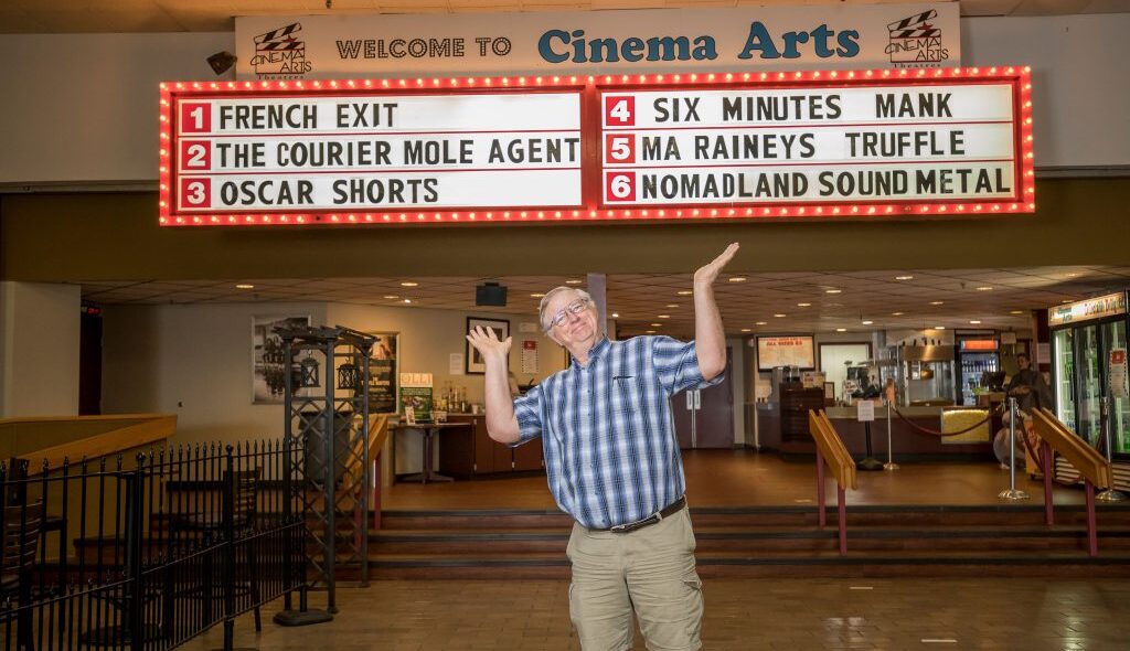 Theater owner in front of marquee