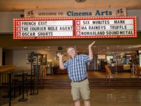 Theater owner in front of marquee